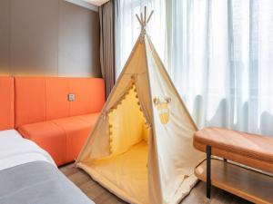 a tent in a bedroom with a bed and a window at LanOu Hotel Shanghai Sheshan National Forest Park Happy Valley in Songjiang