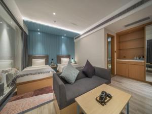 um quarto com uma cama, um sofá e uma mesa em CityNote Hotel Guangzhou Beijing Road Provincial People's Hospital em Guangzhou