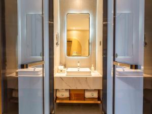 a bathroom with two sinks and a mirror at LanOu Hotel Wanshan Tongren South Expressway Toll Station in Tongren