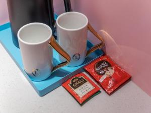 twee koffiemokken op een blauw dienblad op een tafel bij LanOu Hotel Tai'an Taishan Railway Station in Tai'an