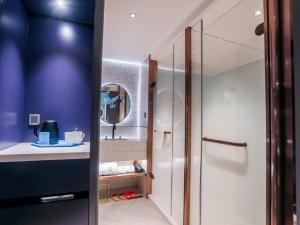 a bathroom with a shower and a mirror at LanOu Hotel Chaozhou Xiangqiao District Plaza in Chaozhou