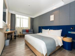 um quarto de hotel com uma cama grande e uma secretária em LanOu Hotel Huai'an Jinhu Suning Plaza West Health Road em Jinhu