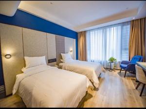 ein Hotelzimmer mit 2 Betten und einer blauen Wand in der Unterkunft LanOu Hotel Heze Mudan District University Town in Heze
