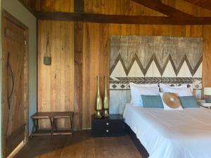 a bedroom with a white bed and wooden walls at Pine Lodge - direct train to Porto in Valongo