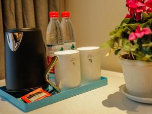 un piano di lavoro con bottiglie di soda e una pianta in vaso di LanOu Hotel Jinzhou Red Star Macalline a Jinzhou