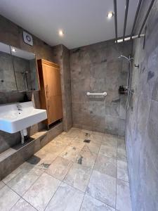 een badkamer met een wastafel en een douche bij The Annex at Meadow Farm in Cambridge