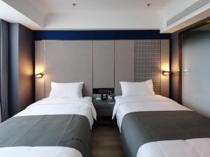 two beds in a hotel room with at LanOu Hotel Taocheng Hengshui Middle School in Hengshui