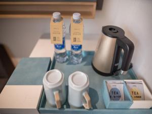 a table with a tea kettle and two bottles of water at CityNote Hotel Guangzhou Beijing Road Provincial People's Hospital in Guangzhou