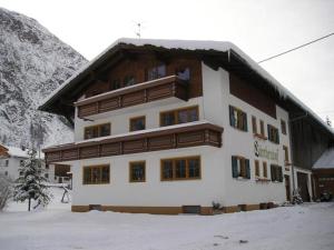 ein großes Gebäude mit Schnee davor in der Unterkunft Haus Lärchenhof in Holzgau