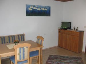 a dining room with a table and a television at Haus Lärchenhof in Holzgau +18 photos