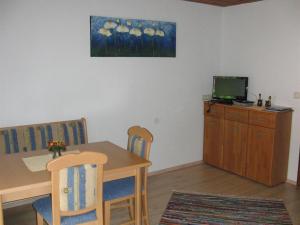 a dining room with a table and a television at Haus Lärchenhof in Holzgau