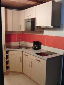 a kitchen with white cabinets and a sink and a microwave at Haus Lärchenhof in Holzgau