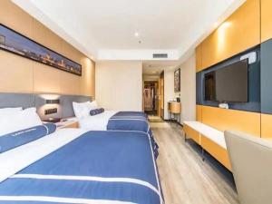een hotelkamer met 2 bedden en een flatscreen-tv bij LanOu Hotel Yancheng Dafeng Yongtai Plaza in Dafeng