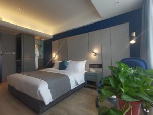 1 dormitorio con 1 cama grande y pared azul en LanOu Hotel Shijiazhuang Luquan Zoo Scenic Spot, en Luquan