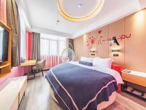 een hotelkamer met een groot bed en een bureau bij LanOu Hotel Yancheng Dafeng Yongtai Plaza in Dafeng