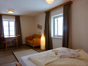 1 dormitorio con cama, silla y ventana en Berghotel Franzenshöhe en Trafoi