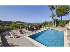 a swimming pool with lounge chairs next to a resort at Belvilla by OYO Cocons in Sineu