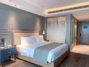 1 dormitorio con 1 cama blanca grande y escritorio en LanOu Hotel Shaoyang Shangbang Jiayuan, en Shaoyang County