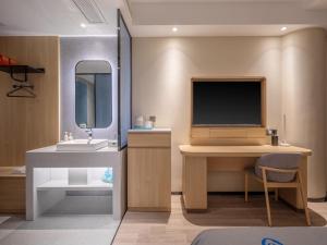 a bathroom with a desk with a tv and a sink at LanOu Hotel Qingdao Golden Beach Scenic Area in Huangdao