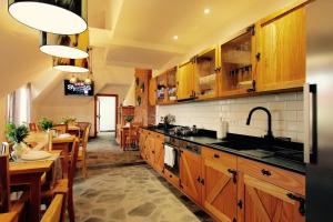 a kitchen with wooden cabinets and a dining room at KOŃSKA GÓRKA Agroturystyka in Rabka-Zdrój
