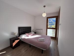 sypialnia z łóżkiem z różową pościelą i oknem w obiekcie BPIRINEOS-Cregüeña w mieście Benasque