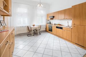 a kitchen with wooden cabinets and a white tile floor at La Lézardière in Norderney