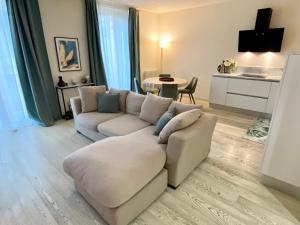 a living room with a couch and a table at Front Beach Deluxe Apartment - with access to beach club in Viareggio
