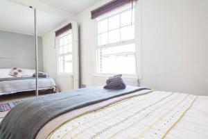 倫敦的住宿－NAVAL COTTAGE IN THE HEART OF ROYAL GREENWICH，一间卧室配有一张床和镜子