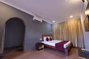 a hotel room with a bed and a window at HOTEL KING PARK in Pondicherry