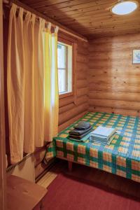 een kleine kamer met een bed in een blokhut bij Saimaan Kultaranta in Puumala
