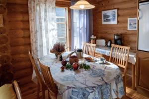 a dining room with a table in a wooden house at Saimaan Kultaranta in Puumala