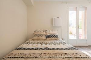 a white bedroom with a bed with pillows at L'Ainstant in Bellegarde-sur-Valserine