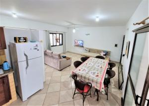 uma sala de estar com uma mesa e um frigorífico em Casa Conforto! A sua casa de praia em Itapoá - SC em Itapoa