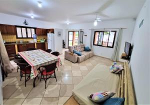 uma cozinha e sala de estar com uma mesa e um sofá em Casa Conforto! A sua casa de praia em Itapoá - SC em Itapoá
