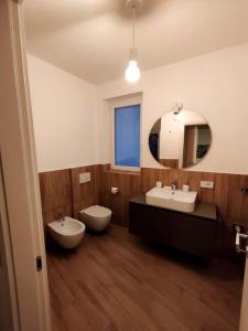 ein Badezimmer mit zwei Waschbecken, einem WC und einem Spiegel in der Unterkunft Apartment near to Como - Donkey's House in Tavernerio