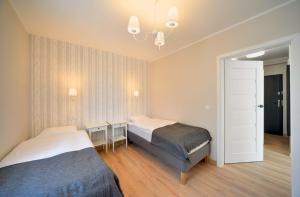 1 dormitorio con 2 camas y lámpara de araña en Apart Invest Szklarska 800 B12 en Szklarska Poręba