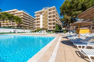 uma piscina com espreguiçadeiras e guarda-sóis em Salou Pacific Rentalmar em Salou