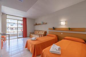 a hotel room with two beds and a window at Apartamento bonito en Salou con piscina in Salou +55 photos