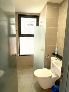a small bathroom with a toilet and a window at The Ash, 3BR Seaview by WStay @ Tropicana 218 Macalister in George Town