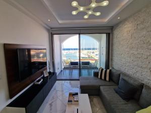 ein Wohnzimmer mit einem Sofa und einem TV in der Unterkunft The Belvedere Latchi Marina in Lachi