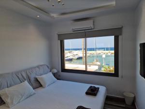 een woonkamer met een bank en een groot raam bij The Belvedere Latchi Marina in Lachi