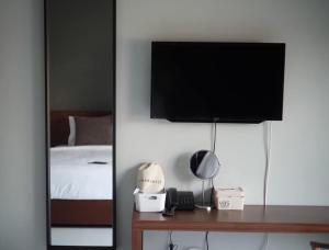 a bedroom with a bed and a television on a wall at Thezen Hotel in Yasothon