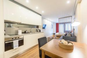 a kitchen and living room with a wooden table and a dining room at Braga Center Apartments - São Vicente in Braga