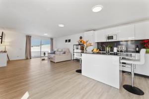 a kitchen and living room with white cabinets at Famara Loft 12 in Famara