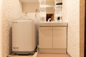 a small kitchen with a sink and a small refrigerator at miyu 灵谷 デザイナーズ和の空間友達グループ最適ゲーム室完備新しいオープン in Osaka +33 photos
