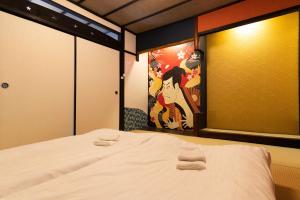 大阪的住宿－miyu 灵谷 デザイナーズ和の空間友達グループ最適ゲーム室完備新しいオープン，一间卧室配有一张床,上面有两条毛巾