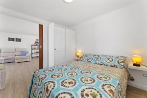 a white bedroom with a bed and a couch at Famara Loft 12 in Famara