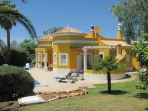 a yellow house with a palm tree in front of it at Vivenda Vista Verde in Portimão