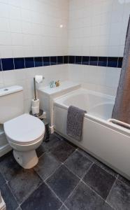 a bathroom with a toilet and a tub and a sink at Blue Anchor House in Maryport