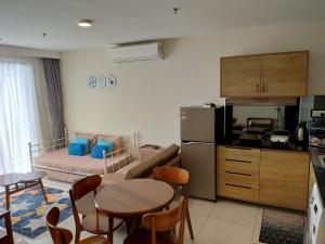 eine Küche und ein Wohnzimmer mit einem Sofa und einem Tisch in der Unterkunft Casa Raudhah @ Timurbay Seafront Residence in Kampung Sungai Karang